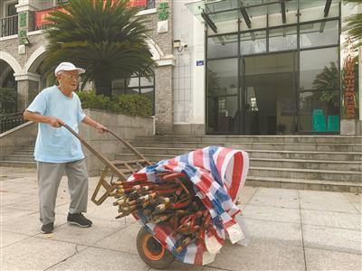 孙如柏推着一车手杖来到社区.