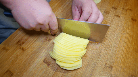 这样土豆能平稳的放在菜板上,然后把土豆切成薄厚均匀的土豆片