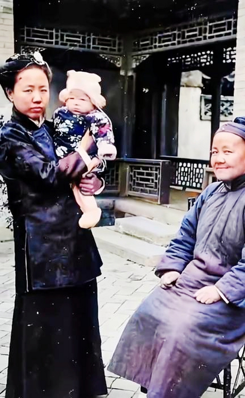 婆婆笑眯眯地坐在桌上,儿媳妇只是抱着孩子站在一旁.