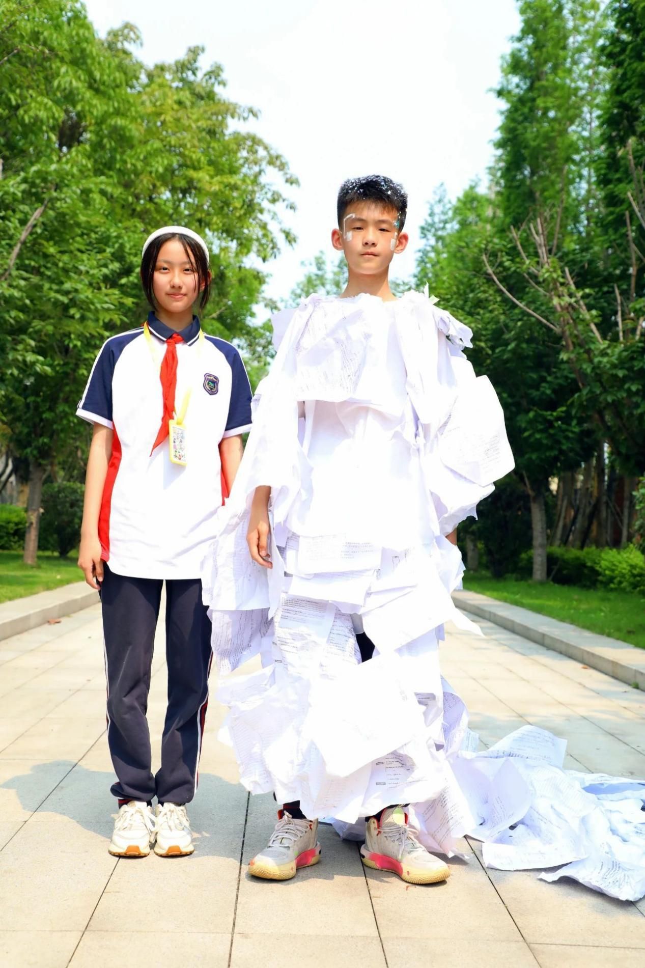 他把塑料雨棚改造成"香奈儿款披风",用树枝插成"维密翅膀",用彩色编织