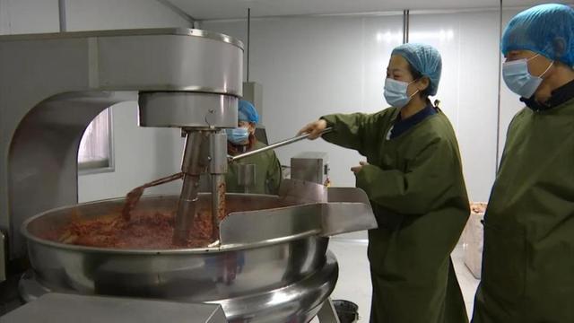 冷菊贞与村民在辣椒酱厂熬辣椒酱.受访者供图