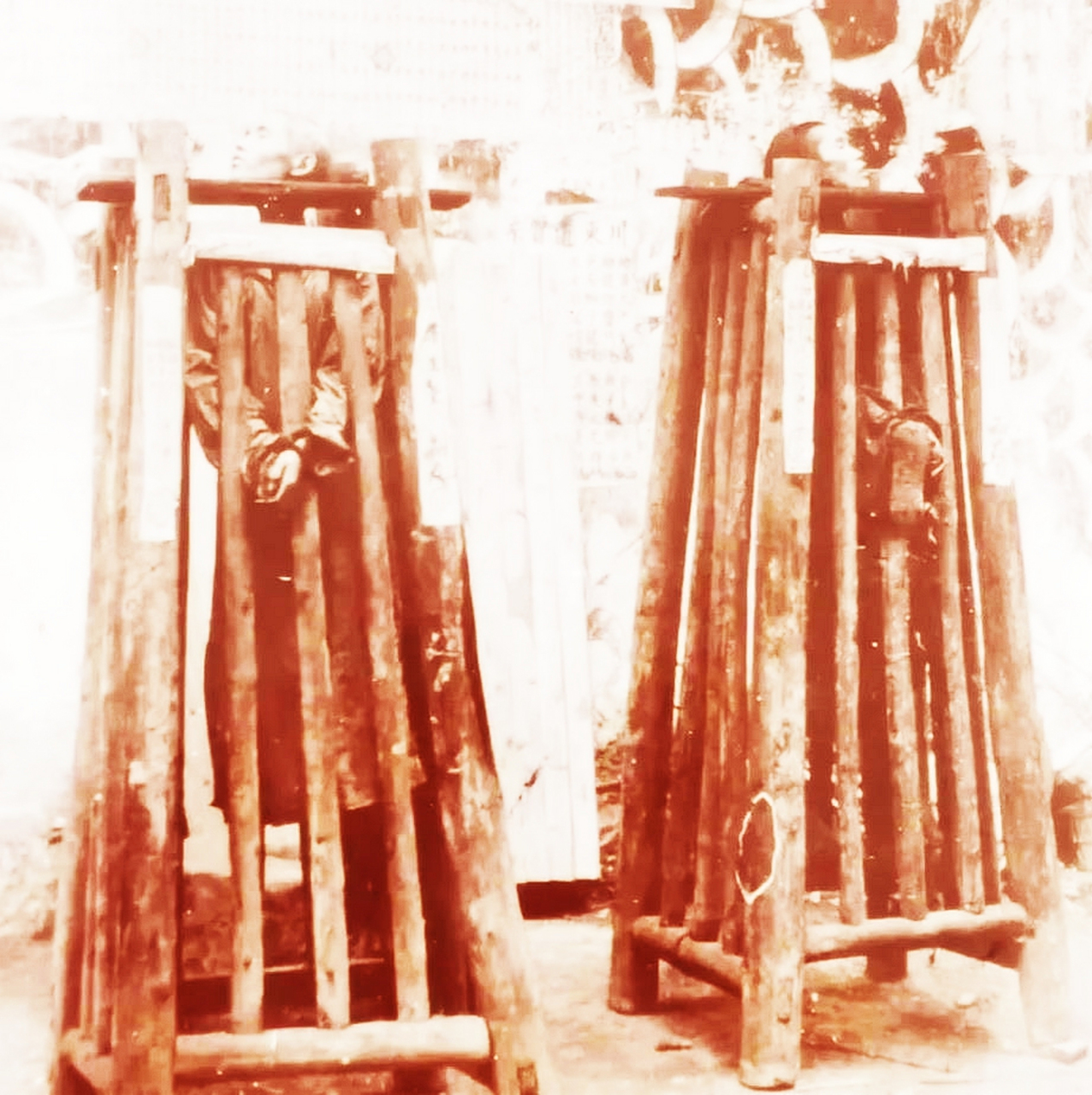 1905年,四川省川东路,两名囚犯被关在铁笼子里,在大街上展示.