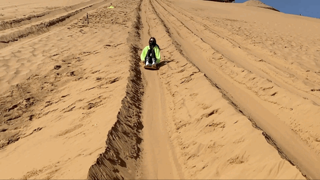 视频中,关晓彤穿着防晒服在沙漠里玩滑沙,爬沙丘,追日落,看星星,画面