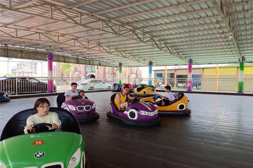 游客在欢乐世界坐碰碰车.