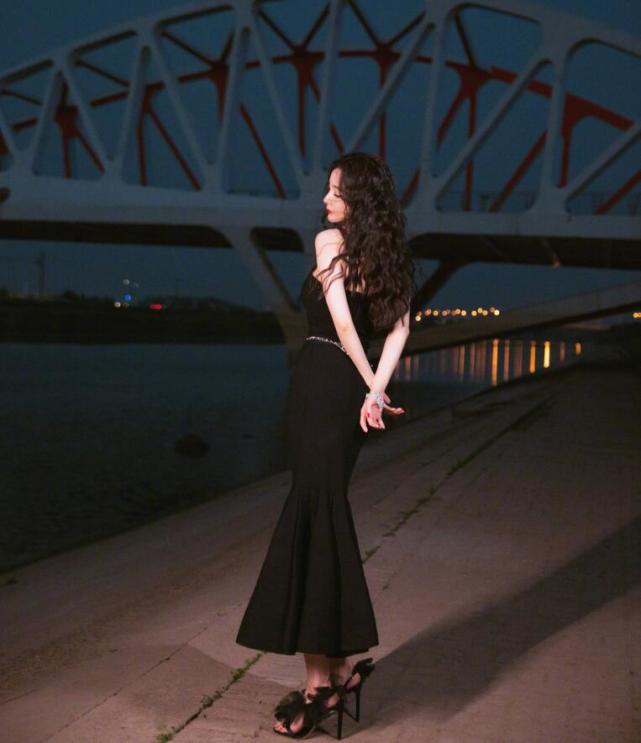 杨幂身穿黑色鱼尾裙,曼妙身姿朦胧妩媚,江边的她比夜色更撩人