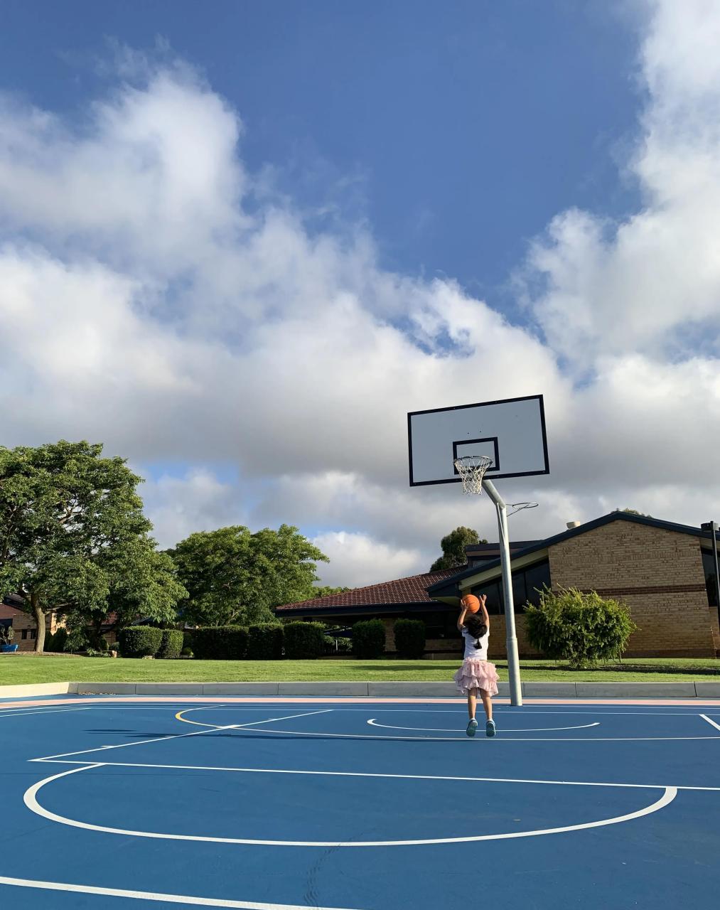 蓝天白云下,孩子的背影都能看出她非常认真投入.