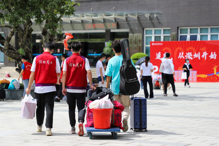 志愿者帮助新生搬运行李(周晓安 摄)