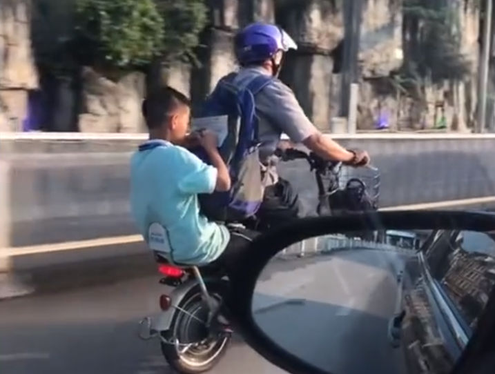 贵州一爸爸骑着电瓶车,儿子趴他后背写作业,如此一幕引起热议!