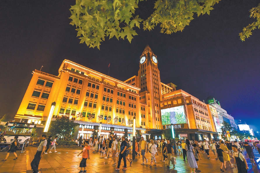 夜晚的王府井步行街上,市民游客摩肩接踵,融入京城繁华夜色.