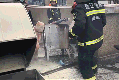 由于楼顶烟道构造死角多,灭火器无法完全扑灭,消防员使用消防斧破开