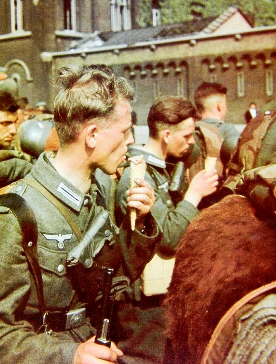 1940年德军占领法国后,一群德军士兵在巴黎街头舔冰淇淋降温.