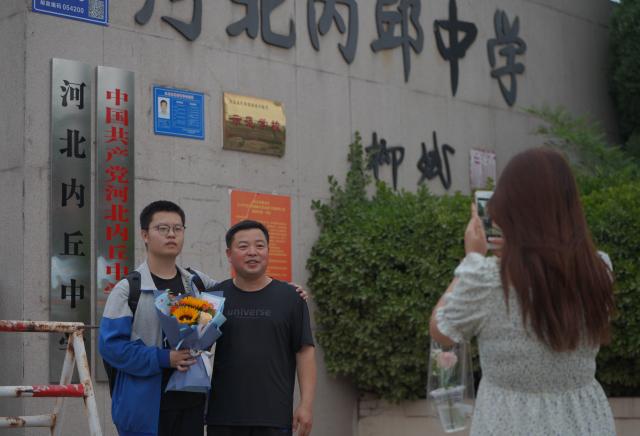 6月9日,河北省邢台市内丘县内丘中学考点,考生和家长在学校门口合影