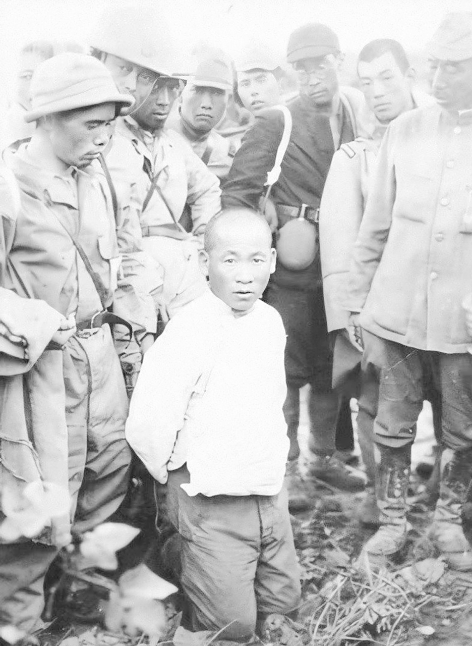 抗日战争时期,三名中国平民被日军俘虏,被迫跪在地上,即将被屠杀.