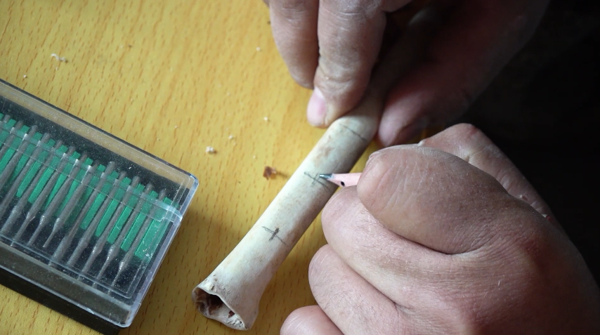 打孔,雕花纹······经过几个小时的努力,一支鹰笛终于制作完成