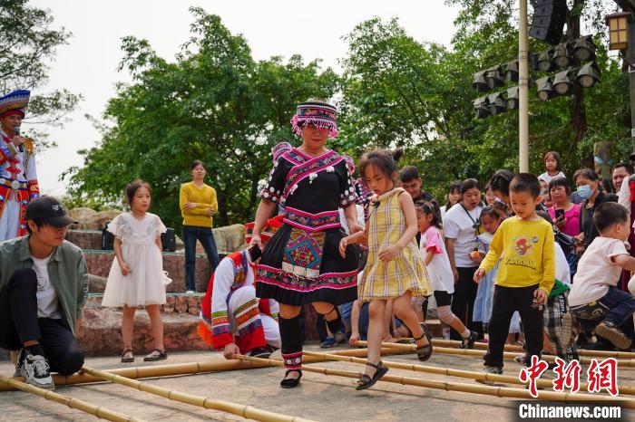 广西壮族三月三:游客共跳竹竿舞