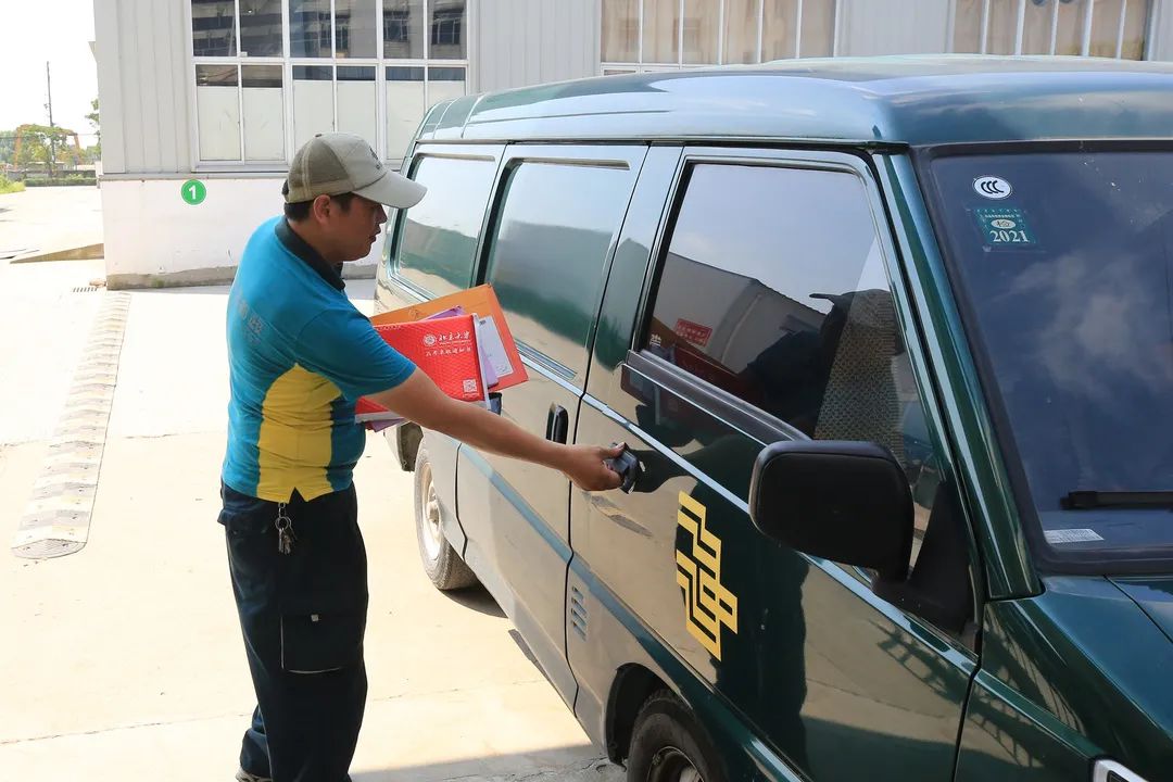 泰兴邮政ems投递小哥 从投递点出发 带着两份录取通知书上门派发!