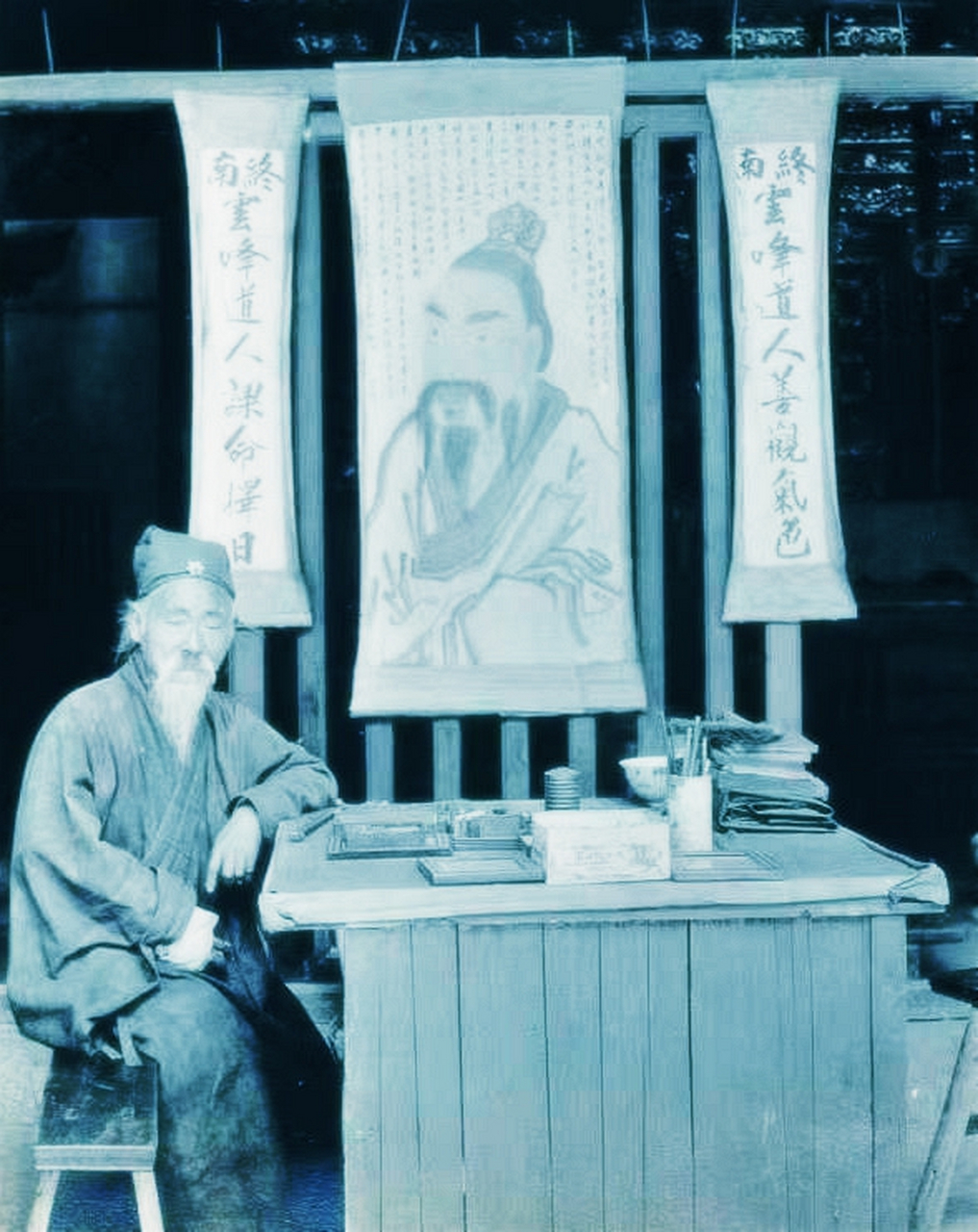 "的算命先生经商的老照片. 一位老人坐在一张桌子旁,拿着工作道具.