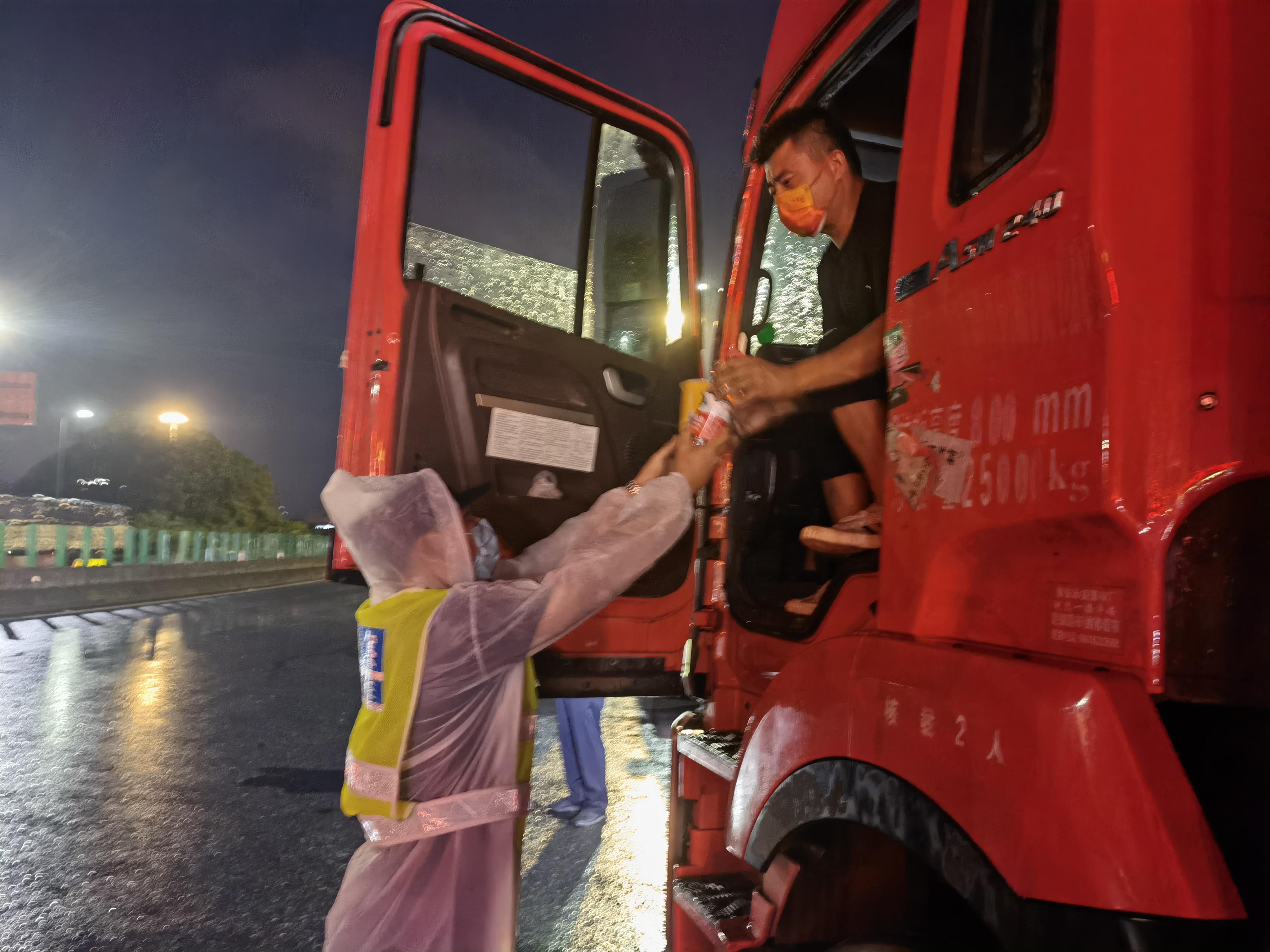 「战"疫"有你·暖新闻」大雨中,民警给货车司机送食物