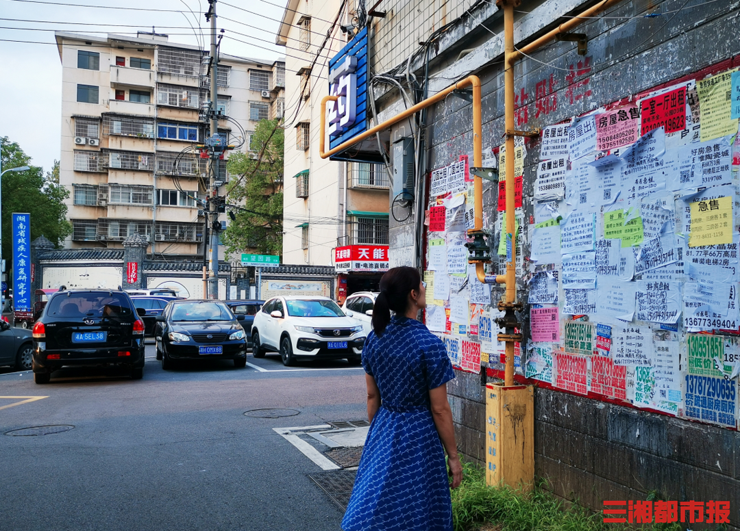 (在位于长沙市芙蓉区嘉雨路附近的一处房产信息公告栏,一位市民正在