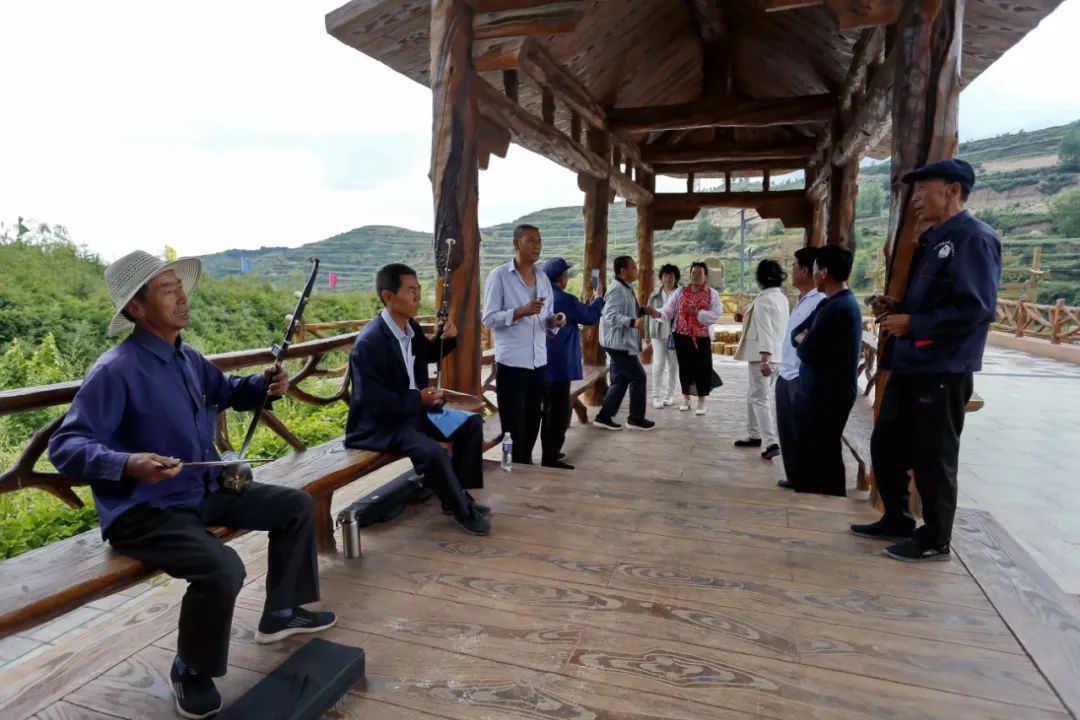 来上寨村旅游的万泉镇果农唱起地摊戏《织手巾》.