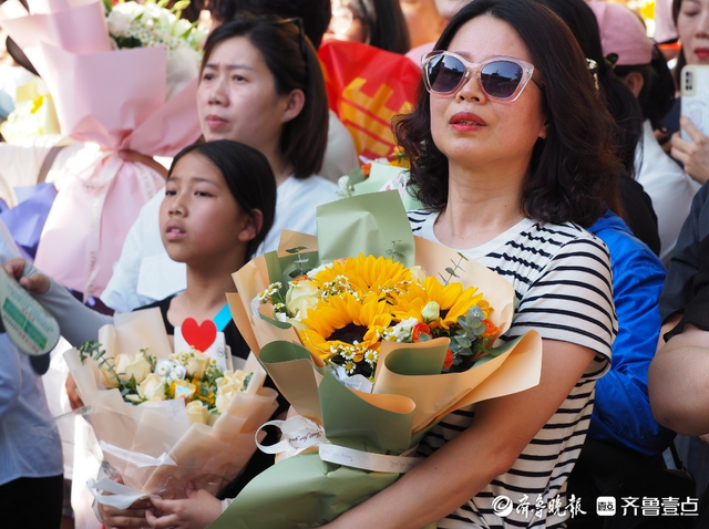 高考考場外,數以百計手捧鮮花的考生親人們滿臉期待