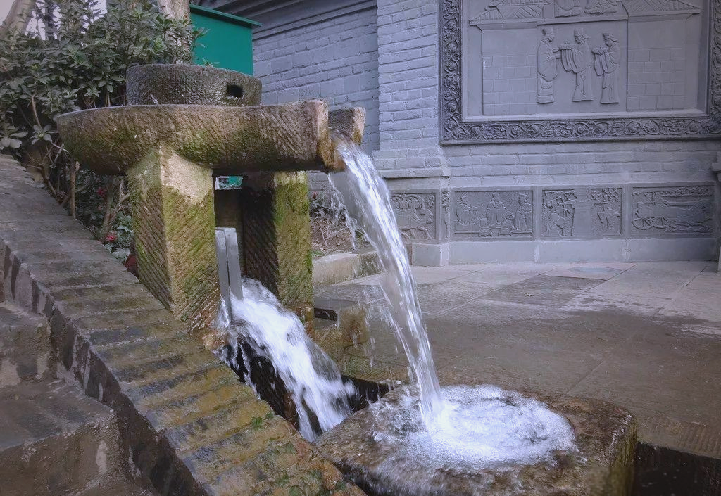 以石磨为灵感打造水景,无疑是一种极具创意的设计