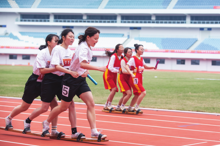 选手们在女子组板鞋竞速2×100米接力预赛中奋力冲刺
