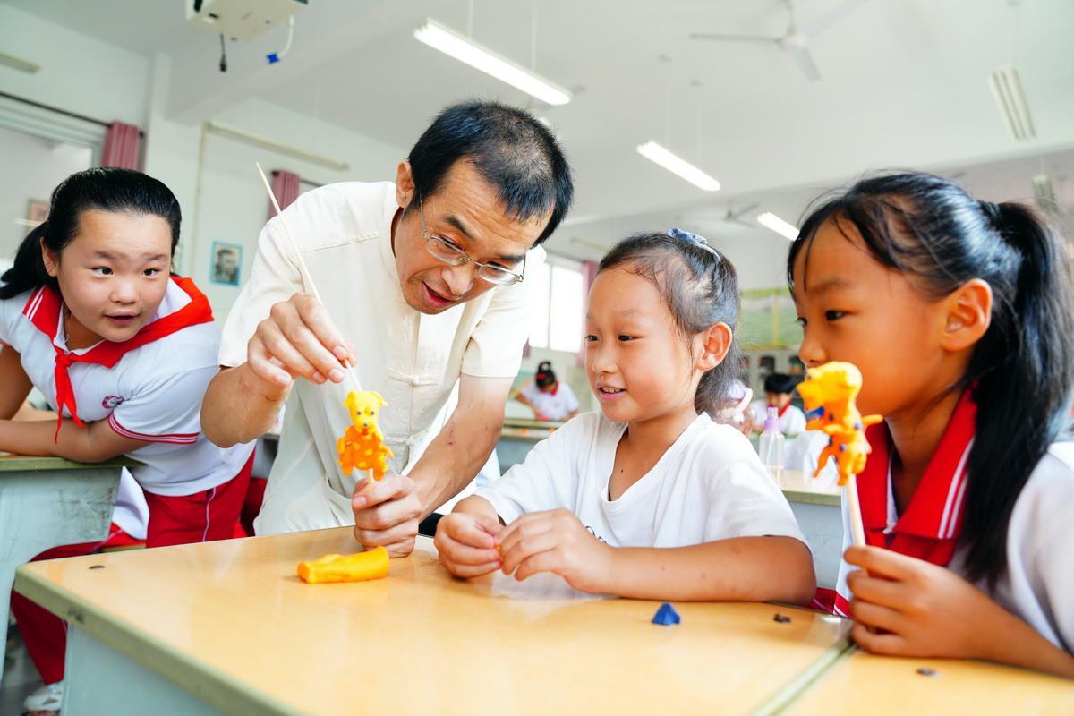 民间老艺人在教小朋友捏面塑