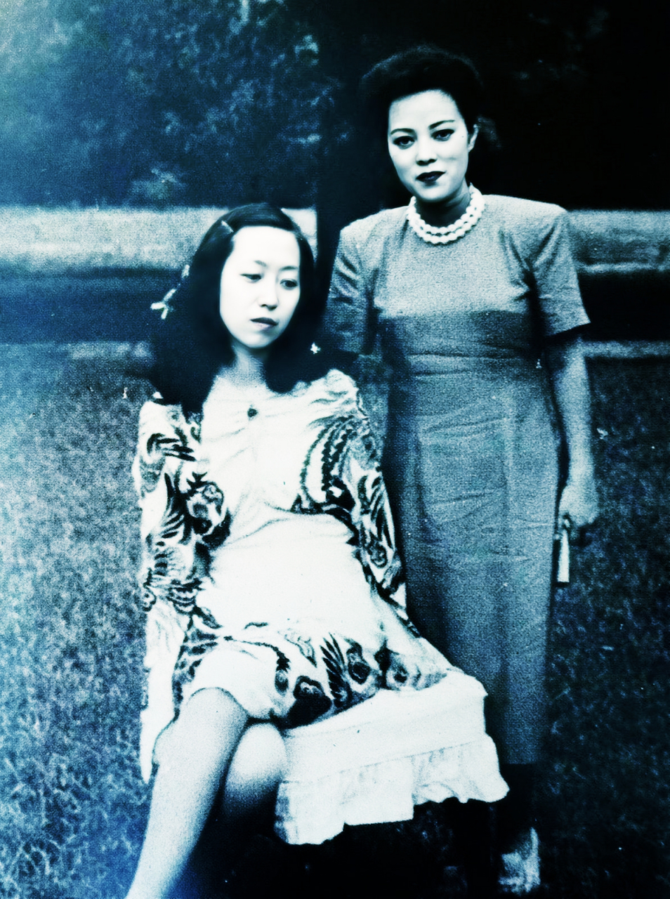 照片中,李香兰身穿旗袍,佩戴珍珠项链,面带微笑,而著名作家张爱玲则靠