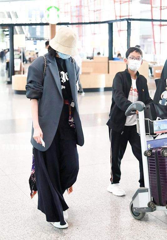 程莉莎真有福气,儿子推行李自己当甩手掌柜,西装配半裙又飒又美