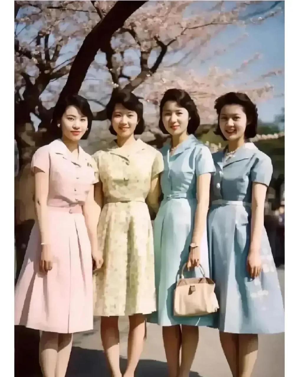 一张80年代的老照片,照片中四个姑娘穿着不同颜色的连衣裙,她们端庄