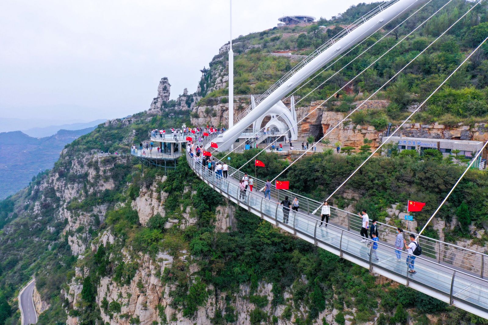 国庆佳节,喜迎"中国红"!淄博潭溪山高空玻璃桥五星飘扬