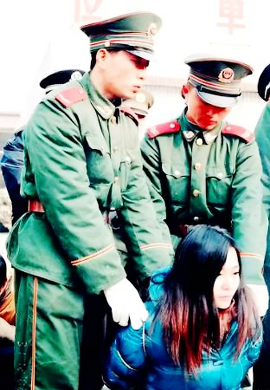 1990年代,一名年轻貌美的死刑犯被铐上手铐跪在地上等待死刑.