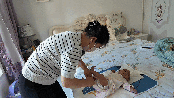 4月嫂殷万喜正在给婴儿换尿布.gif