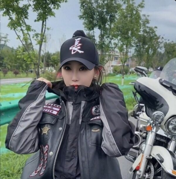 穿着警察制服的女性骑警员在户外休息，背景有摩托车和绿树。