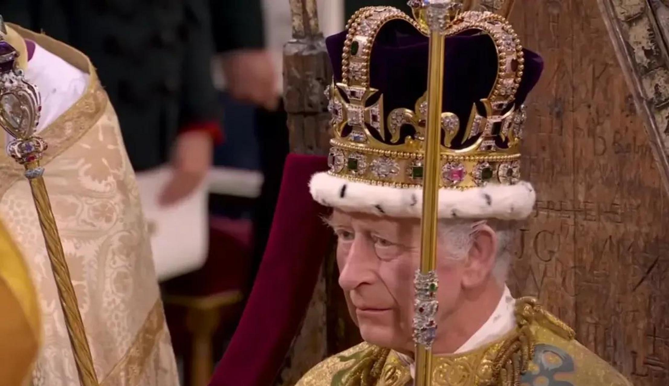 查尔斯三世国王黄袍加身,头戴二千克的圣爱德华王冠,手持王室权杖和