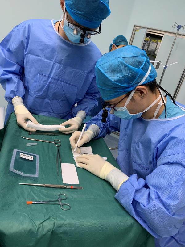 手术中,王鹏程医生(右一)在制作肺动脉带瓣管道.