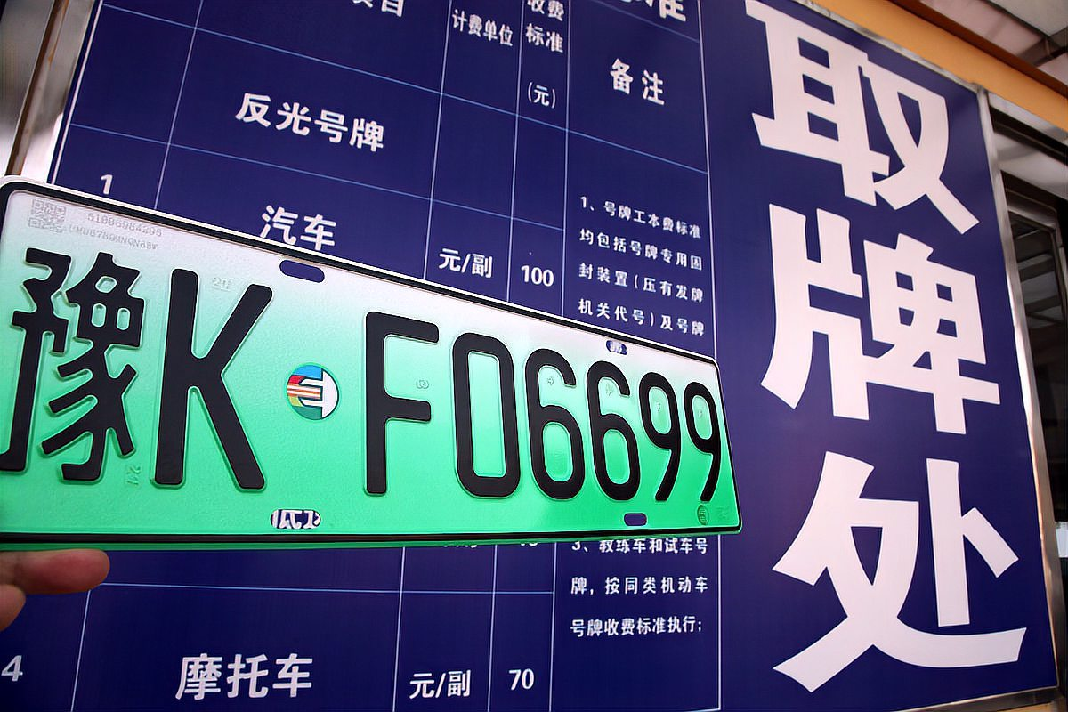 悬挂的车辆牌照“粤K F06699”与背景大牌上的取牌规定信息
