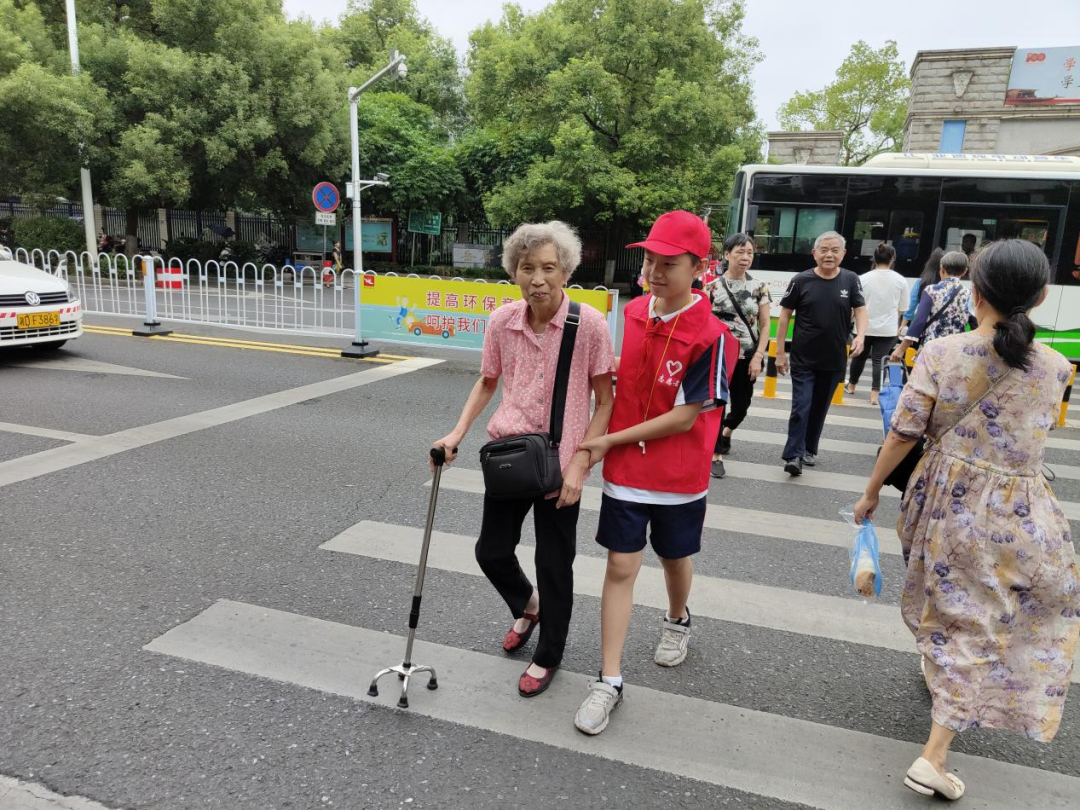 孩子攙扶著老奶奶過馬路