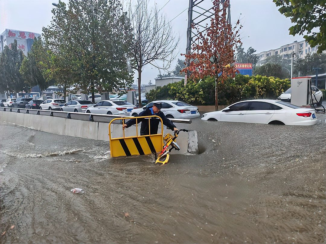 暴雨引发洪水，骑行者试图穿越积水路段