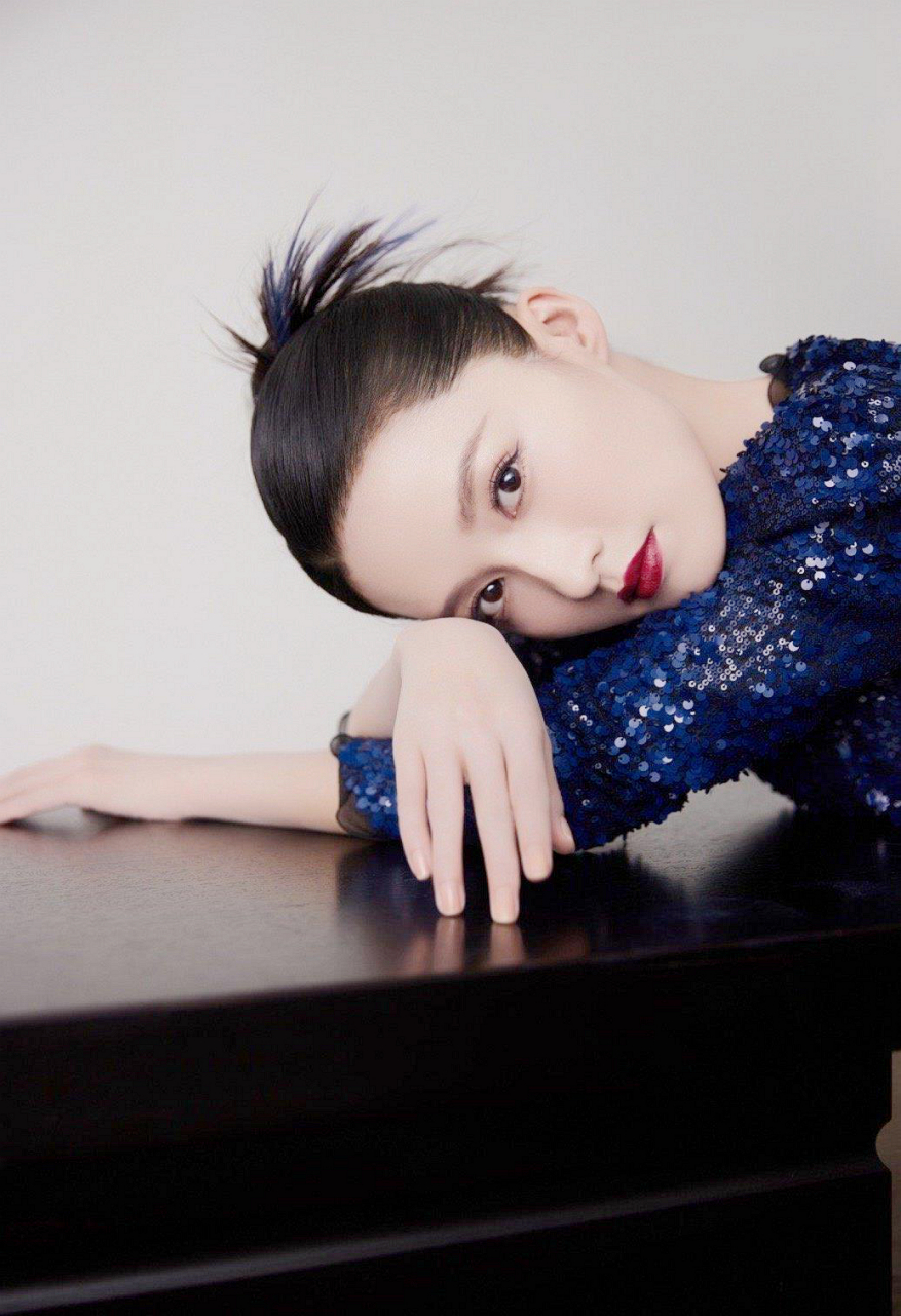 李沁打着一把大气感十足的雨伞,黑色亮片连衣裙完美的凸显了他的身材