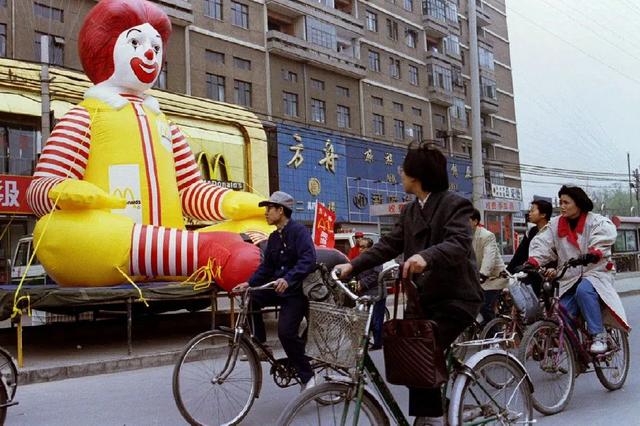 1990年代,北京街头,骑着自行车的行人被麦当劳的广告气球吸引