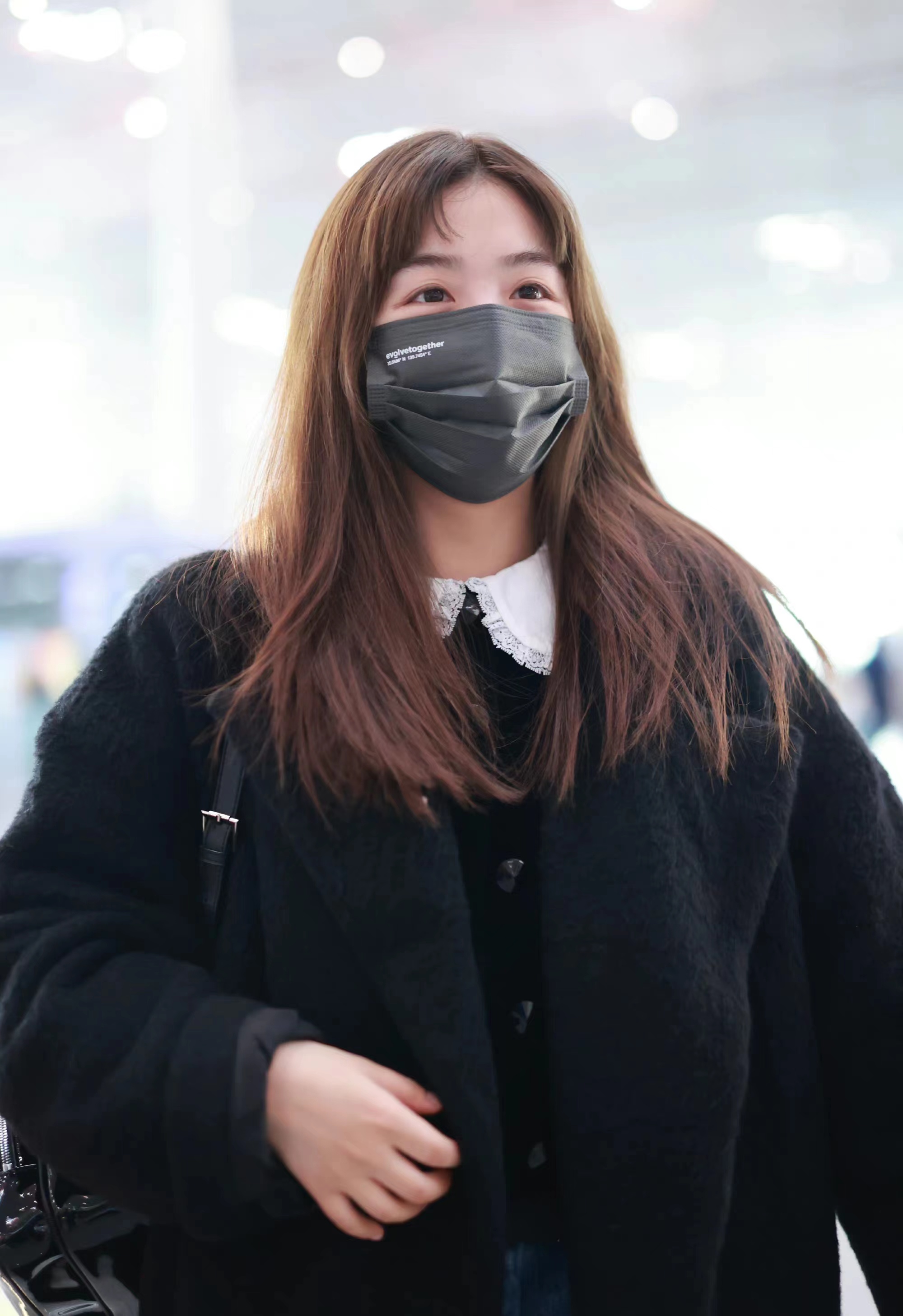 张含韵现身机场,长款黑色大衣搭娃娃领毛衣,甜美又减龄!