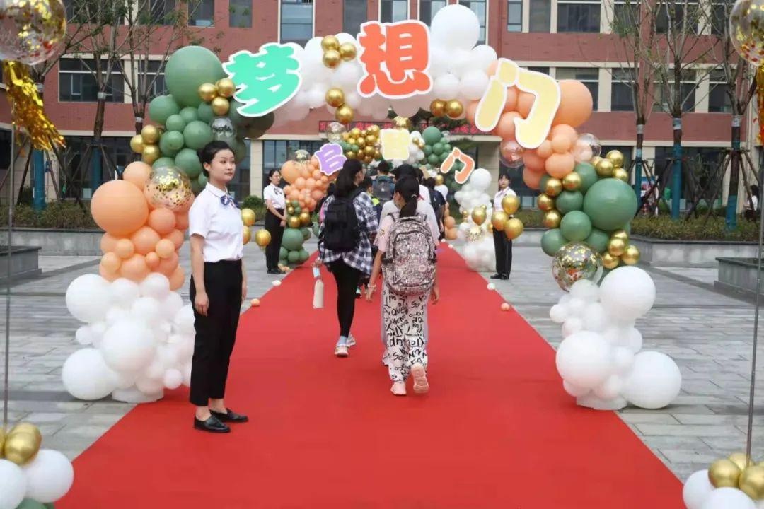 重庆路中学(北校区)的学生们在签名墙签上名字,走过"梦想门,进入
