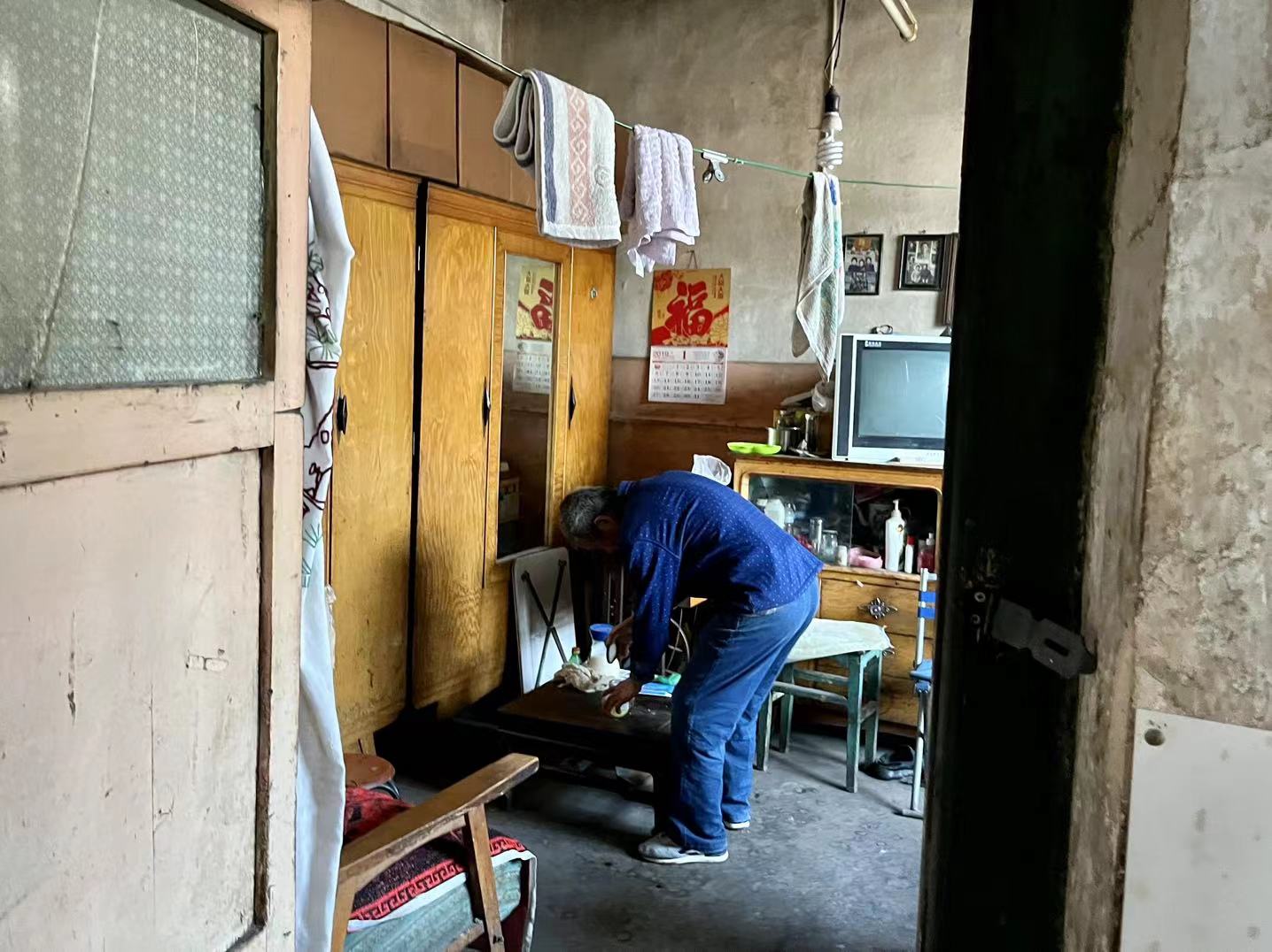 魏忠在屋里找东西.摄影:席小丹