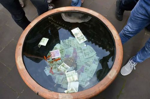 女子带孩子在景区捞许愿池硬币,引热议