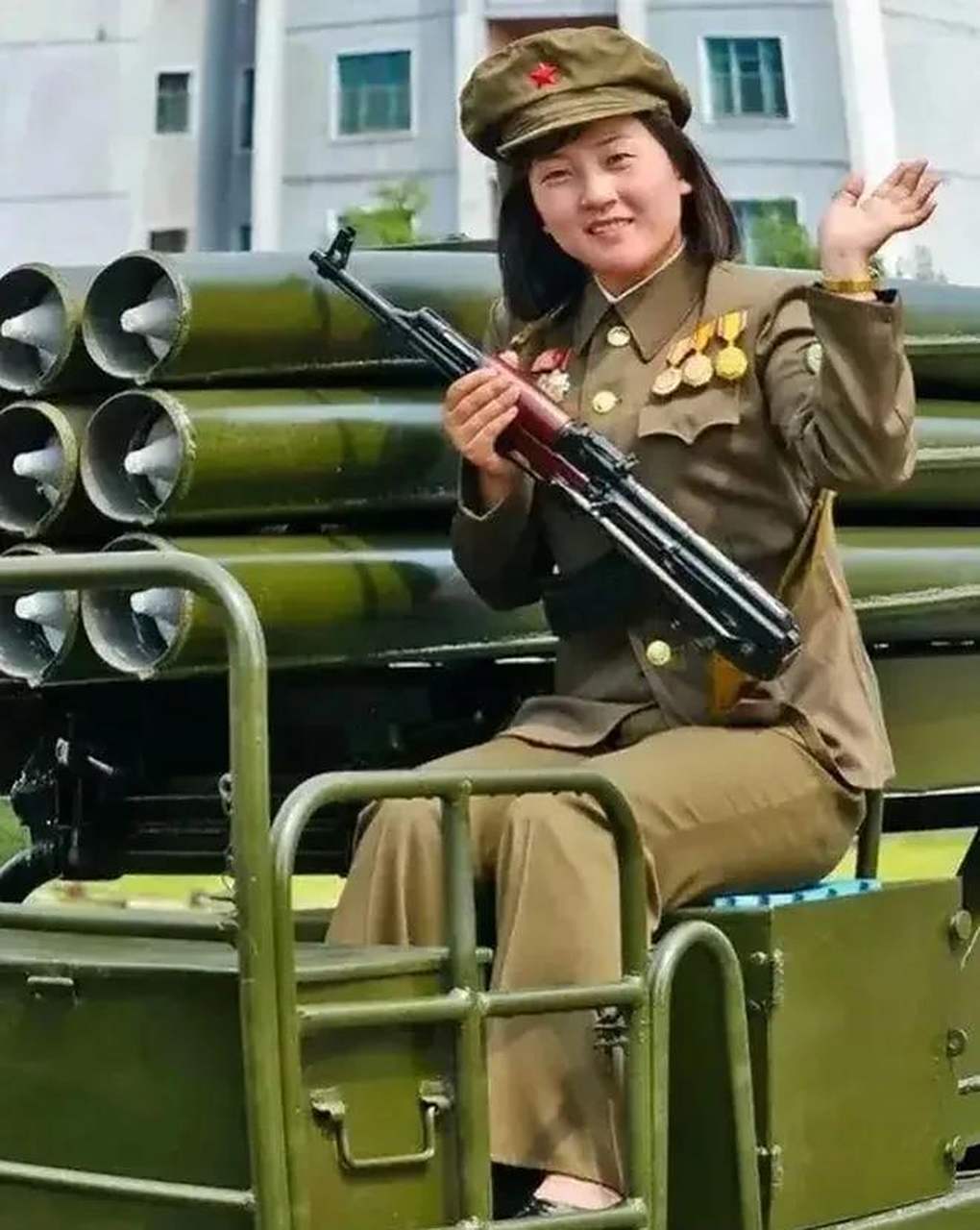 在朝鲜2002年的阅兵仪式上,一位女兵站在一辆装甲车上,抱着她的冲锋枪