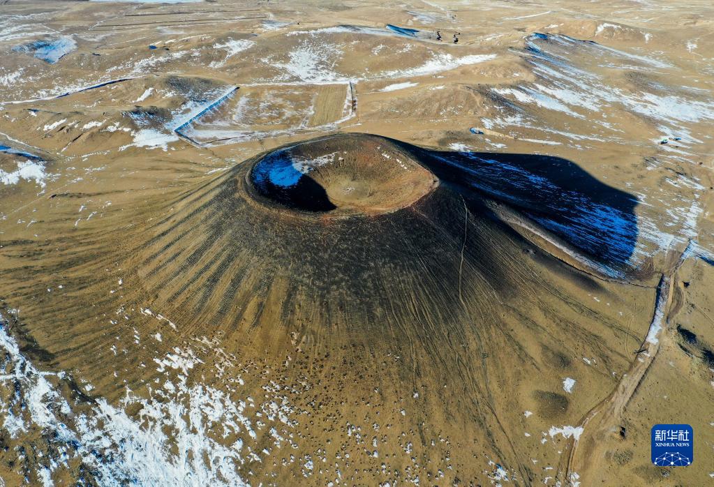 冬日乌兰哈达火山与草原残雪相映成趣