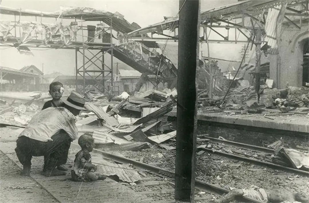 老照片里的故事——1937年日军轰炸上海南站,坐在铁轨上大哭的男孩,活