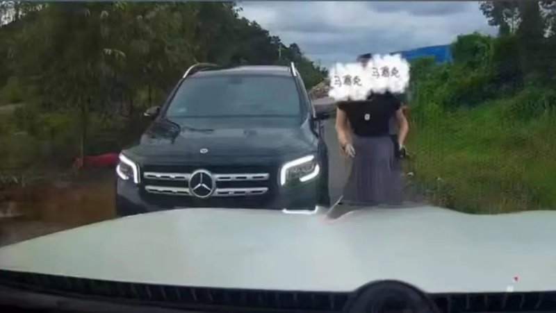 道路遇险：黑色奔驰SUV与一名女子在乡村道路上相遇